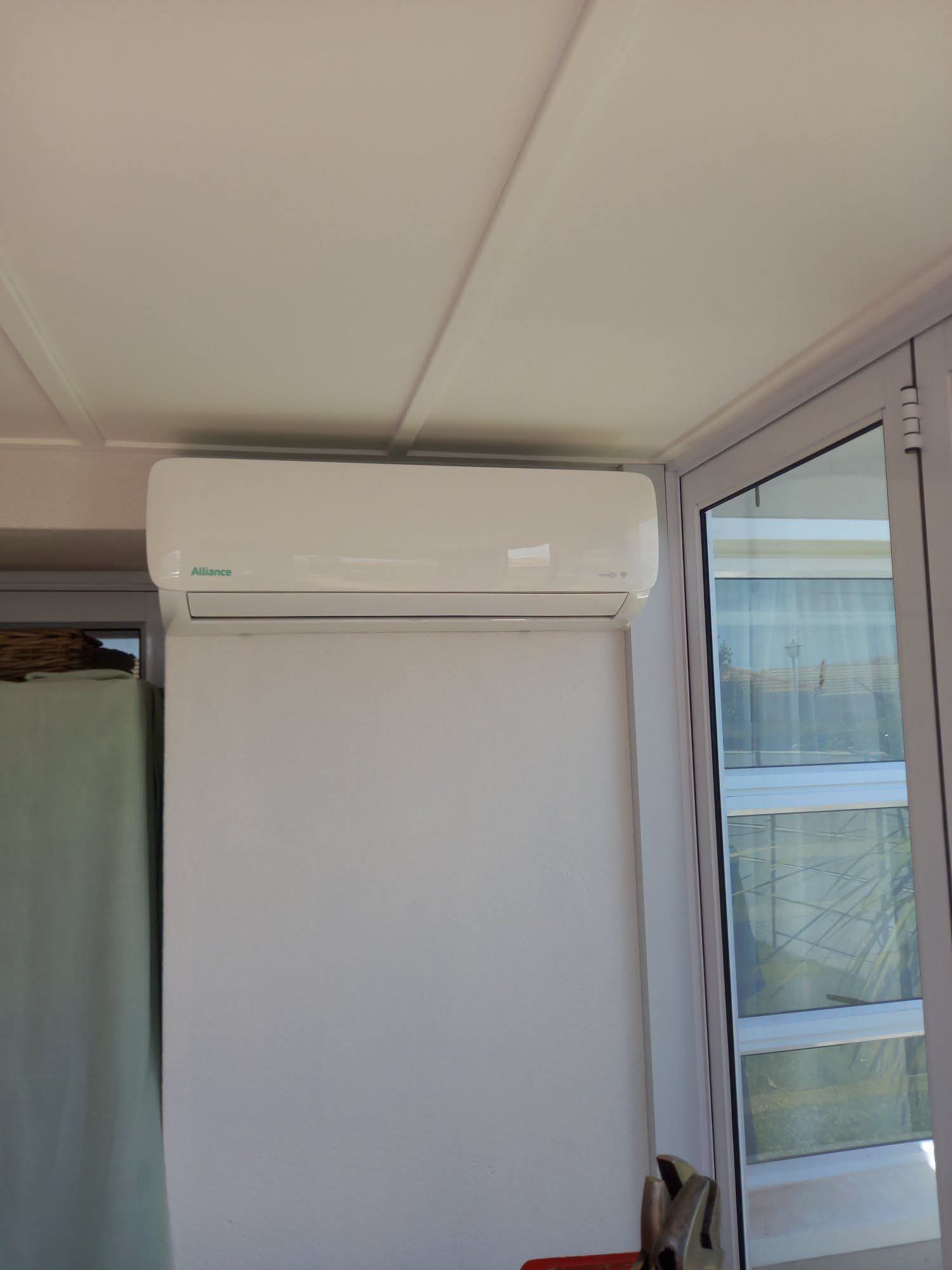 Alliance wall-mounted air conditioning unit installed on an enclosed patio