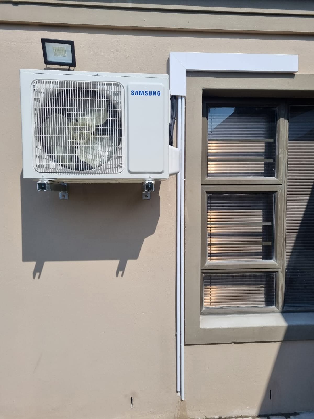 Completed Samsung outdoor air conditioning unit installation mounted on exterior wall