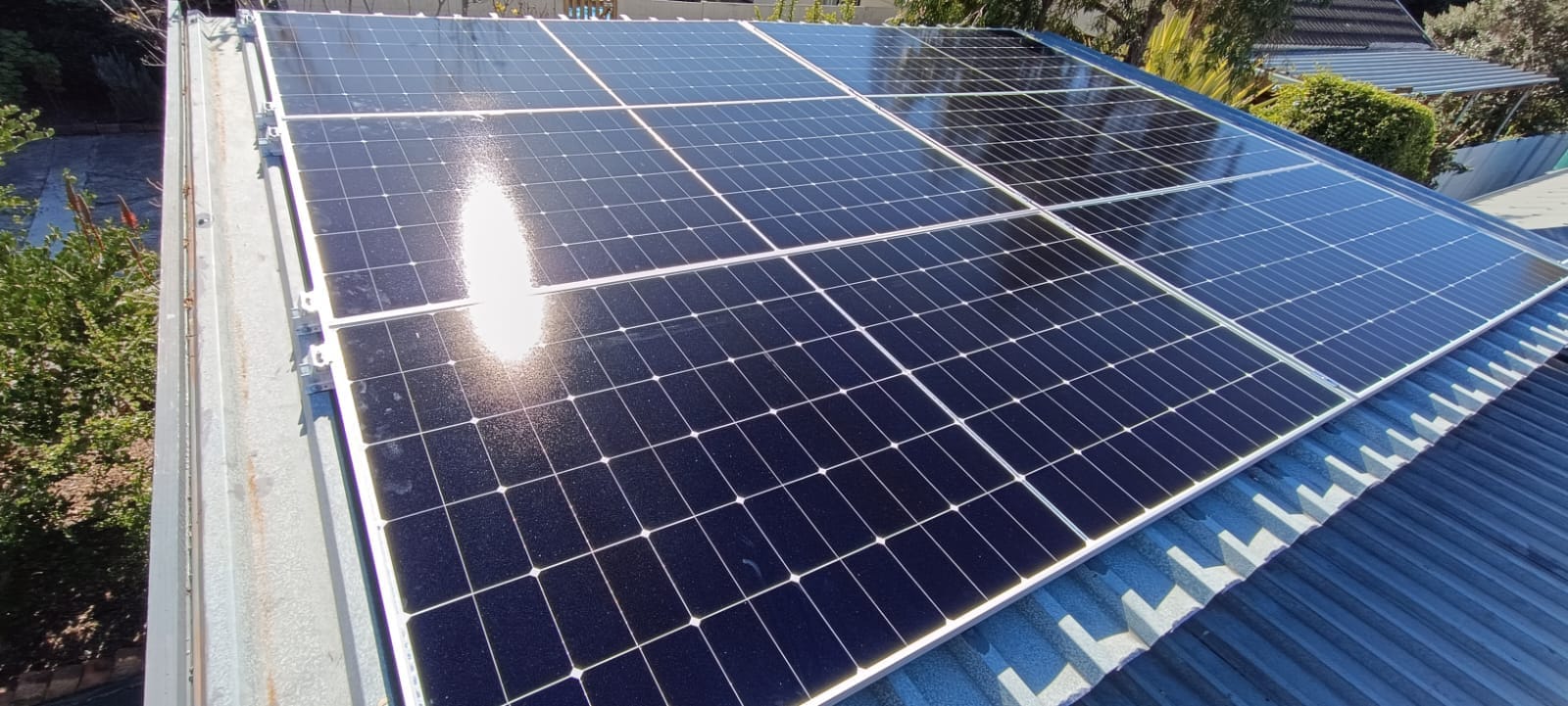 Close-up of solar panels installed on a corrugated tin roof